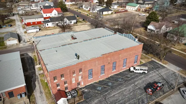Aerial view of a brick commercial building with a flat roof in a small town