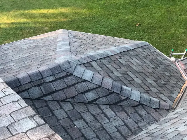 Shingled hip roof ridge with ridge cap shingles