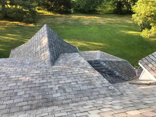 Aerial view of a hip roof and valleys covered in light gray shingles